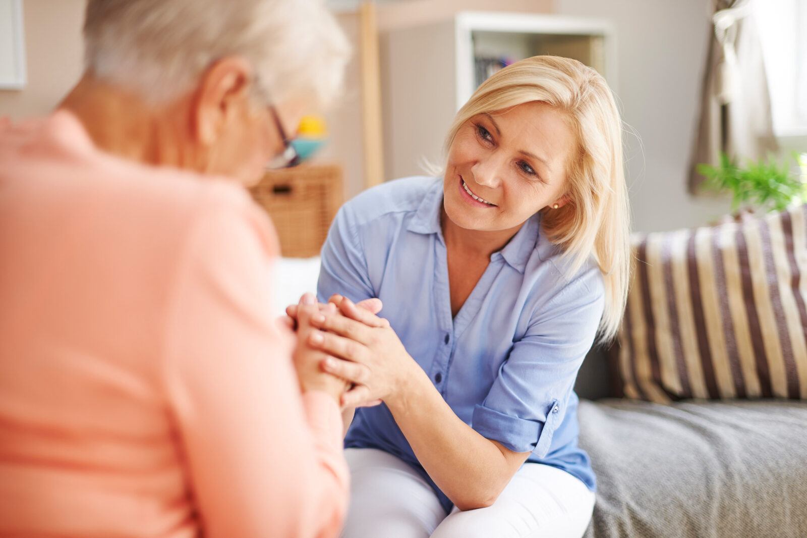 Pflegekraft des Bestlüd Pflegeteams im vertrauensvollen Gespräch mit einer Seniorin
